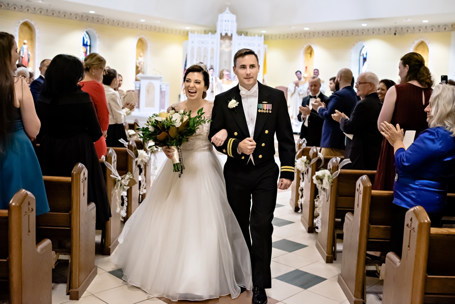 A newly married couple walk out of the church after saying I do.